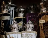 Srebrne korony i ozdobne zwoje Tory, przypominające o królewskiej chwale i mądrości z Psalmu 21.