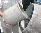 Se vierte agua de un cubo a otro, preparándose para proporcionar cemento y agua.