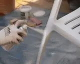 Application d'un apprêt sur une chaise blanche. Le temps de séchage de l'acétone avant peinture est crucial pour une finition parfaite.