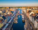 Navigazione nel porto di Copenaghen, con case colorate, barche a vela e un vivace lungomare.