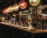 Elegant bar i en michelin restaurang Stockholm. Vackra glaslampor, blommor och uppdukade bord skapar en lyxig atmosfär.