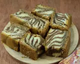 Kawałki ciasta zebra ułożone na drewnianej desce, z charakterystycznymi pasami jasnego i ciemnego ciasta.