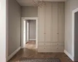 En hall med en stor garderob i ljusgrått och fiskbensparkett. Perfekt grå hall inspiration för ett modernt hem.