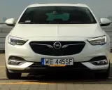 Biały Opel Insignia 2.0 Turbo z polskimi tablicami WE 445SF zaparkowany na dachu.