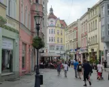 Spacer po urokliwej uliczce z kolorowymi kamienicami, idealne miejsce na zielona góra atrakcje na weekend. Ludzie spacerują, siedzą w kawiarniach.