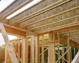 Estructura de madera de una casa en construcción, mostrando las partes de un apeo y vigas del techo.
