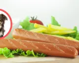 Czy pies może jeść parówki? Na zdjęciu piesek obok parówek i frytek.
