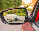 Riflesso nello specchietto: persona a terra dopo un incidente. Un caso di omissione di soccorso stradale.