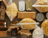 Zapasy żywności na czas wojny: makaron, kasza, konserwy, ciastka, kawa, cukier i miód.