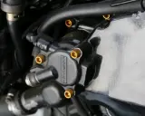 Elementy układu hydraulicznego motocykla, widoczna regulacja pedału sprzęgła hydraulicznego.