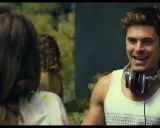 Il cast di We Are Your Friends, Zac Efron con le cuffie al collo, sorride mentre parla con qualcuno fuori campo.