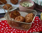 Gyldene chicken nuggets i en friteringskurv, nylagade i airfryer. Serveras med en krämig dipp.