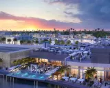 Un moderno complesso sul Jeddah port con piscina a sfioro, ristoranti all'aperto e yacht ormeggiati al tramonto.