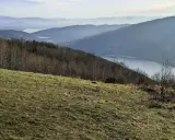 Widok na jezioro i góry w Beskidach. Idealne miejsce na krótkie szlaki w Beskidach, gdzie można podziwiać malownicze krajobrazy.