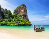 Idealna pogoda na Phuket w listopadzie: spokojne morze, piaszczysta plaża i tradycyjna łódź.