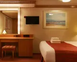 Accogliente cabina interna crociera con letto, specchio, scrivania e TV.