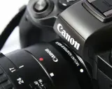 Zbliżenie na czarny aparat cyfrowy Canon z obiektywem.
