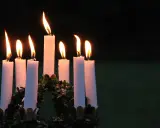 Sju ljus brinner i en krans, en påminnelse om vad betyder namnet Lucia: ljus.