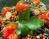 Ensalada de lentejas con tomates cherry, aceitunas negras y perejil fresco. Un plato saludable y lleno de sabor.