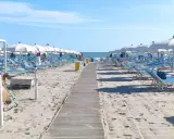 Spiaggia di Misano Adriatico: file di lettini e ombrelloni bianchi pronti per accogliere i bagnanti. Cosa vedere? Il mare azzurro e la sabbia dorata!