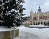 Świąteczna choinka na Rynku Głównym w Krakowie, otoczona śniegiem. To jedna z głównych kraków atrakcje zimą.