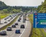 Korek na autostradzie A4 w kierunku Katowic. Samochody stoją w długim sznurze, a znaki drogowe wskazują drogę do Krakowa i Tynca.