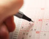 Ręka zaznacza liczby na kuponie lotto. Czy to będą szczęśliwe liczby dla byka w lotto?