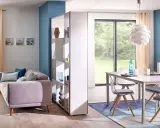Aménagement salle à manger moderne avec canapé confortable et table design. Une étagère sépare les espaces.