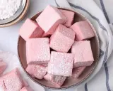 Dulces cubos rosados, como se hacen las nubes de azúcar, espolvoreados con azúcar glas.