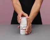Hände halten eine Flasche Olaplex Nr. 6 Bond Smoother, ein Leave-in Styling Treatment für Feuchtigkeit und Stärke.