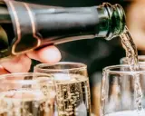 Un verre se remplit de bulles fines, promesse du meilleur champagne rosé. Une célébration pétillante commence.