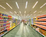 Alejka w supermarketach, pełna produktów na półkach. Widać kartony z płatkami śniadaniowymi i napojami. To typowe sklepy po angielsku, gdzie można znaleźć wszystko.