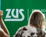 Ludzie słuchają o składce zdrowotnej 2026 przy zielonym logo ZUS.