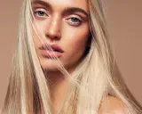 Blondynka z lśniącymi włosami, które wyglądają jak po użyciu płukanki rozjaśniającej.