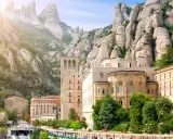 Klasztor Montserrat wznosi się wśród skalistych szczytów, z budynkami o architekturze przypominającej czcionkę Montserrat.