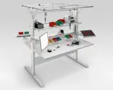 Poste de travail industriel optimisé pour la norme ergonomie, avec écran, bacs de rangement et outils organisés pour une efficacité maximale.