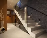 Nowoczesna klatka schodowa inspiracje: szkło, kamień i drewno tworzą elegancką przestrzeń.