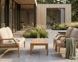 Trädgårdsmöbler i teak med klassisk design, placerade på en altan vid ett modernt hus.