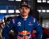 Max Verstappen im Rennanzug, bereit für das 24h Rennen. Sein Blick ist fokussiert, die Red Bull-Logos sind deutlich sichtbar.