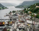 Il pittoresco porto di Bergen, con le sue case colorate affacciate sull'acqua e le colline verdi che fanno da sfondo.