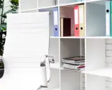 Scrivania ordinata con sedia bianca e scaffali pieni di raccoglitori colorati, perfetti per chi cerca idee su come organizzare i documenti di casa.