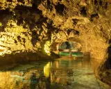 Beleuchtete Höhlen von São Vicente mit einem ruhigen Wasserbecken und Aquarien.