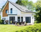 Maison moderne avec balcon, terrasse et jardin. Un projet de construction de maison qui respecte le budget.