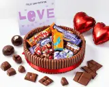 Pastel de xuxes con forma de tarta, decorado con chocolates y globos en forma de corazón. ¡Un regalo perfecto para San Valentín!
