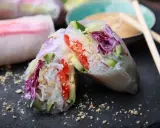 Frische, bunte Sommerrollen mit Reisnudeln, Gurke, Tomate und Rotkohl, bestreut mit Erdnüssen. Perfekt für einen leichten Snack.