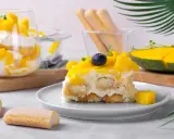 Un délicieux tiramisu mangue, garni de fruits frais et de biscuits à la cuillère. Une touche tropicale pour un dessert rafraîchissant.