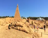Beeindruckende Sandskulpturen, darunter der Eiffelturm, im Sand City Algarve. Besucher bestaunen die Kunstwerke.