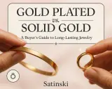 Due mani mostrano un bracciale e un anello, confrontando quanti tipi di oro ci sono: placcato e massiccio.