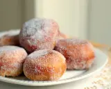 En tallrik med gammaldags munkar, pudrade med socker. Perfekt för ett mysigt fika.
