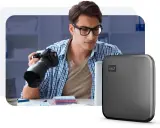 Fotograf z aparatem i dysk WD z technologią Thunderbolt 3.